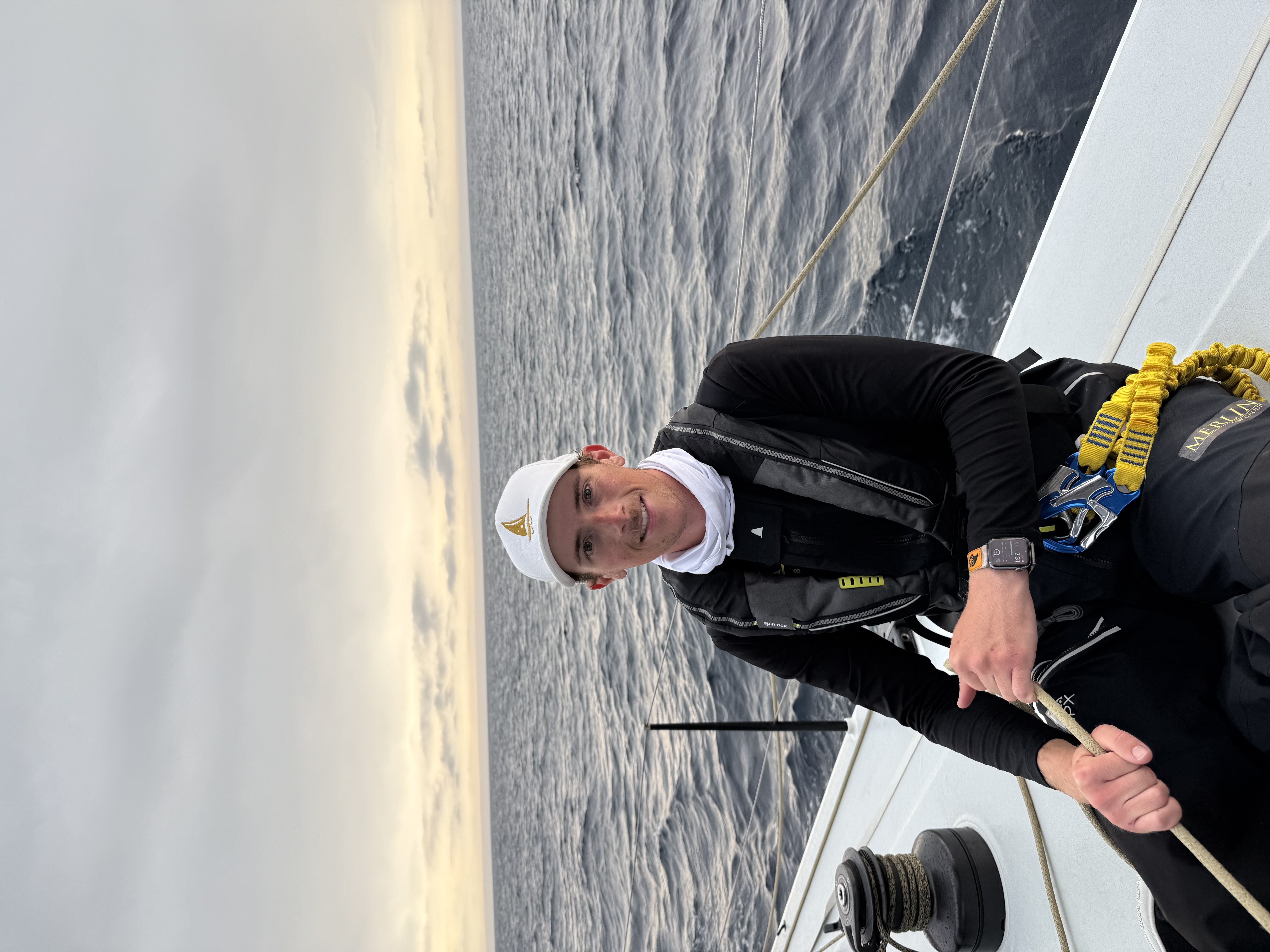 Photo is of a 21 year old male holding the spinnaker sheet onboard Merlin. 